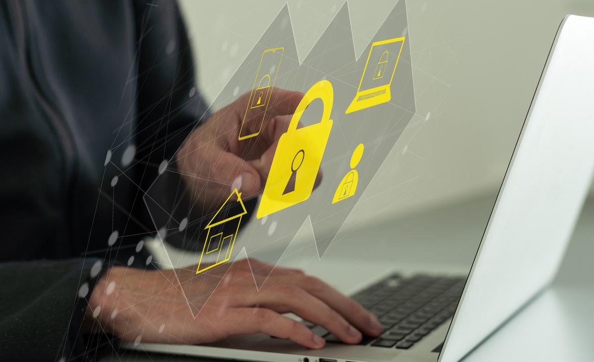 Man using tablet with security icons floating around