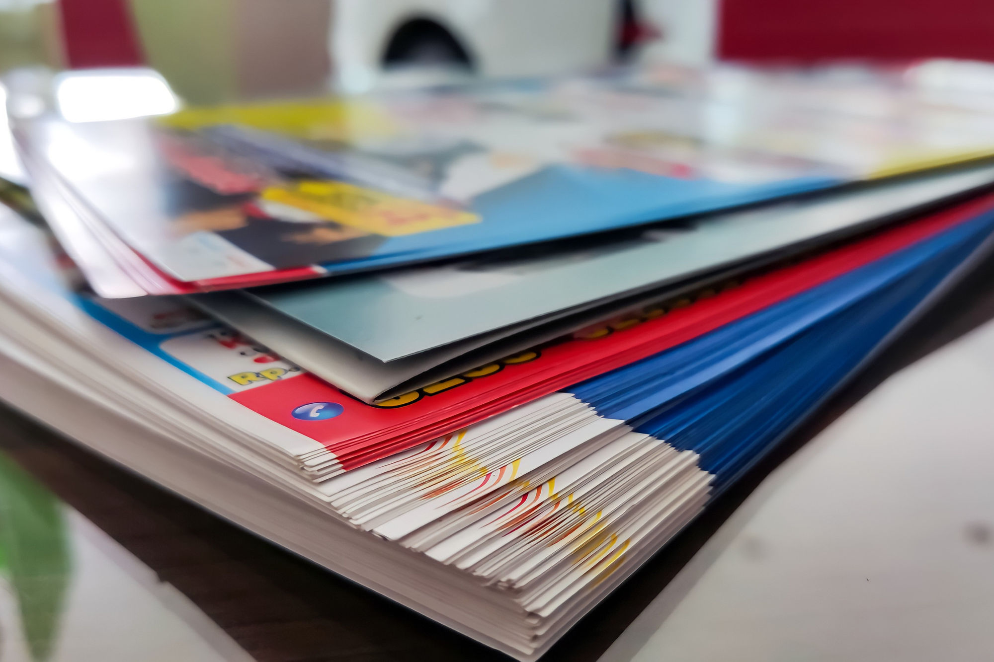 Pile of brochures in blue, with white and red accents