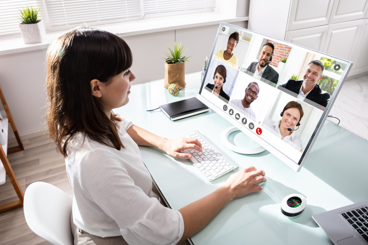 A woman working from home, in a video call with other people working from home remotely.