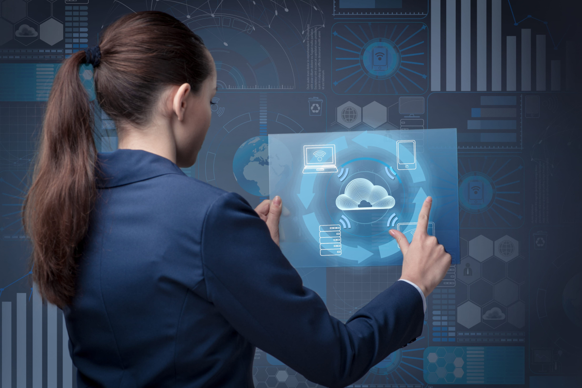 Woman reviewing cloud computing services on a transparent display.
